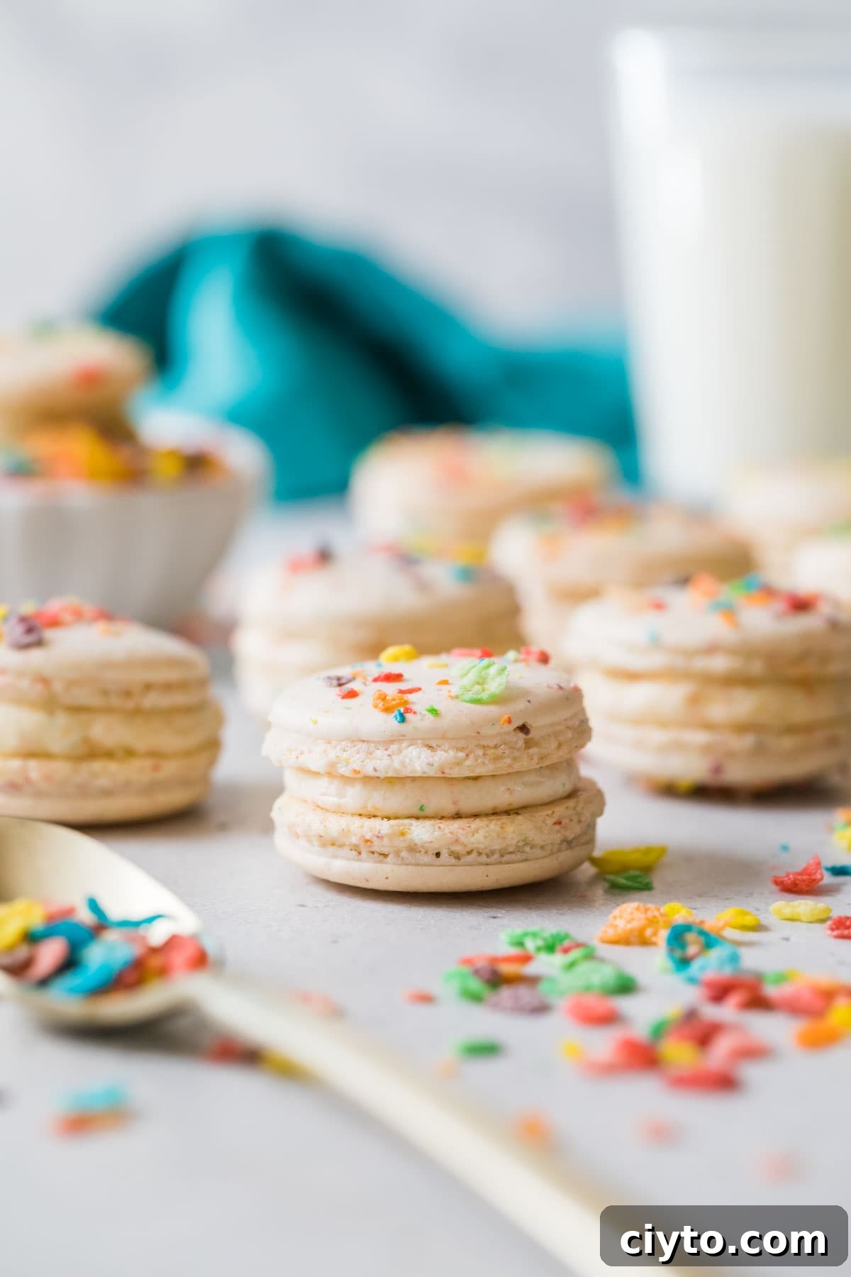 Fruity pebble macarons on a white countertop.