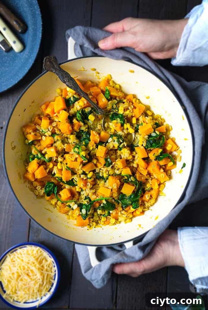 Creamy Butternut Squash Barley Risotto with Spinach and Corn 2 A skillet with barley and squash dish being placed on the table.