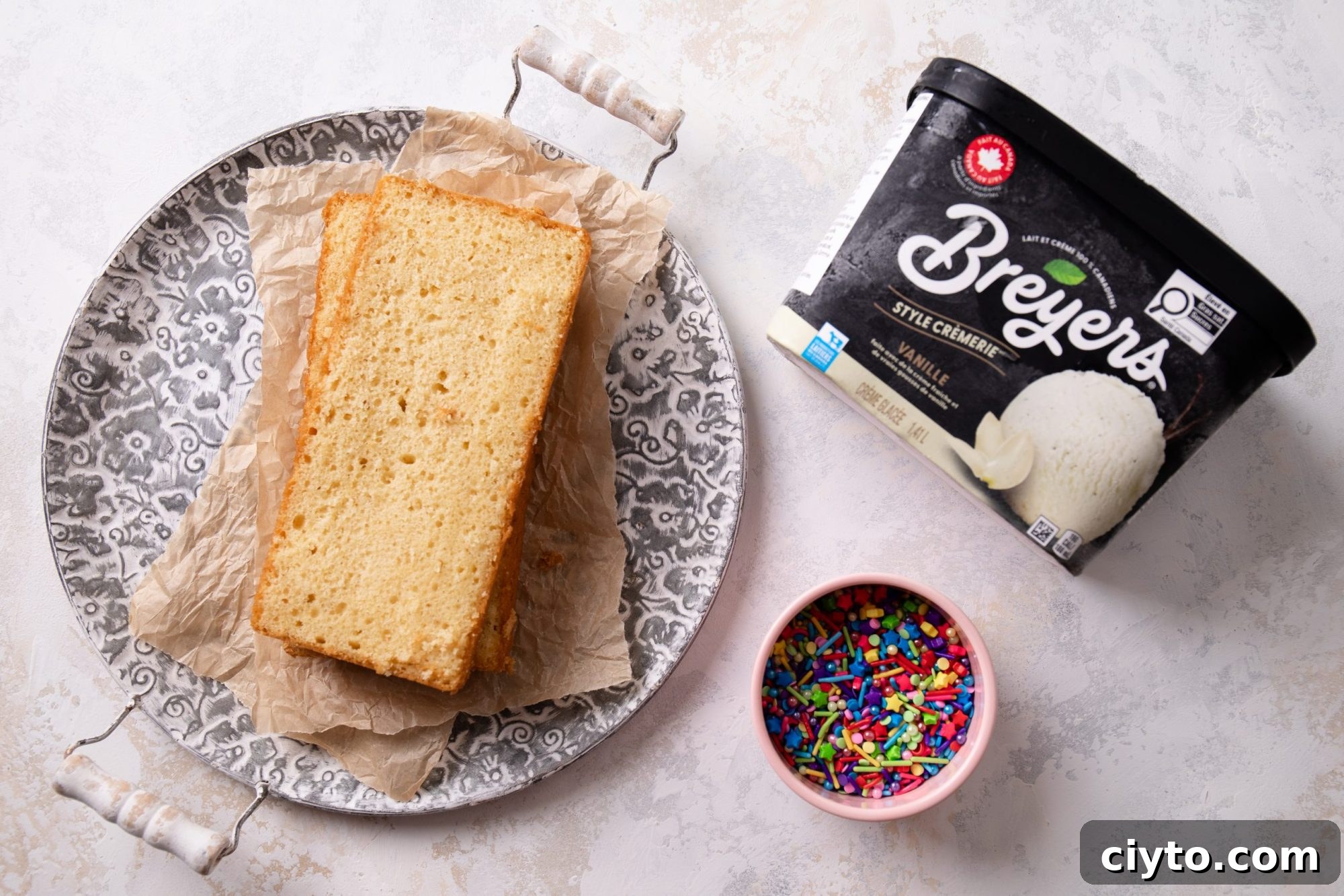 An overhead shot of the 3 ingredients needed to make an ice cream loaf cake; a prepared loaf cake or pound cake, ice cream, and sprinkles. | bbe