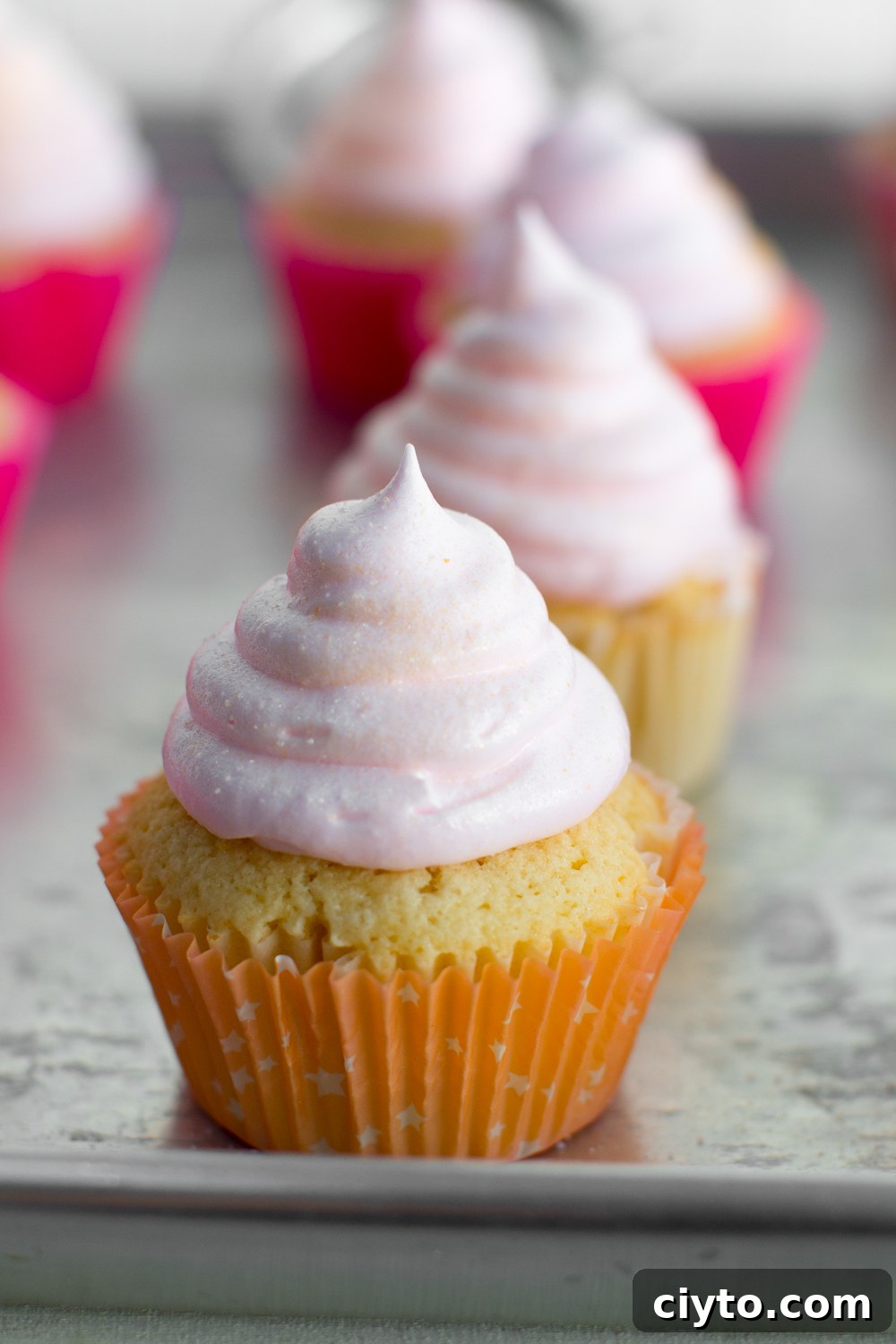 a super close up shot of a finished pink champagne meringue cupcake