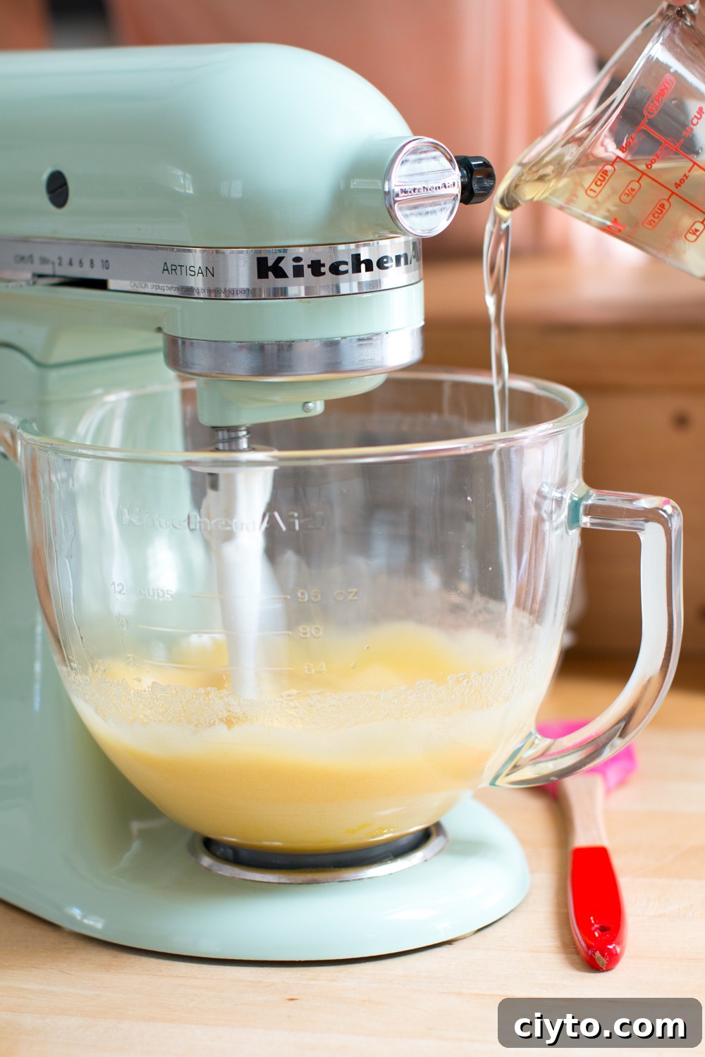 pouring coconut oil into the cupcake batter