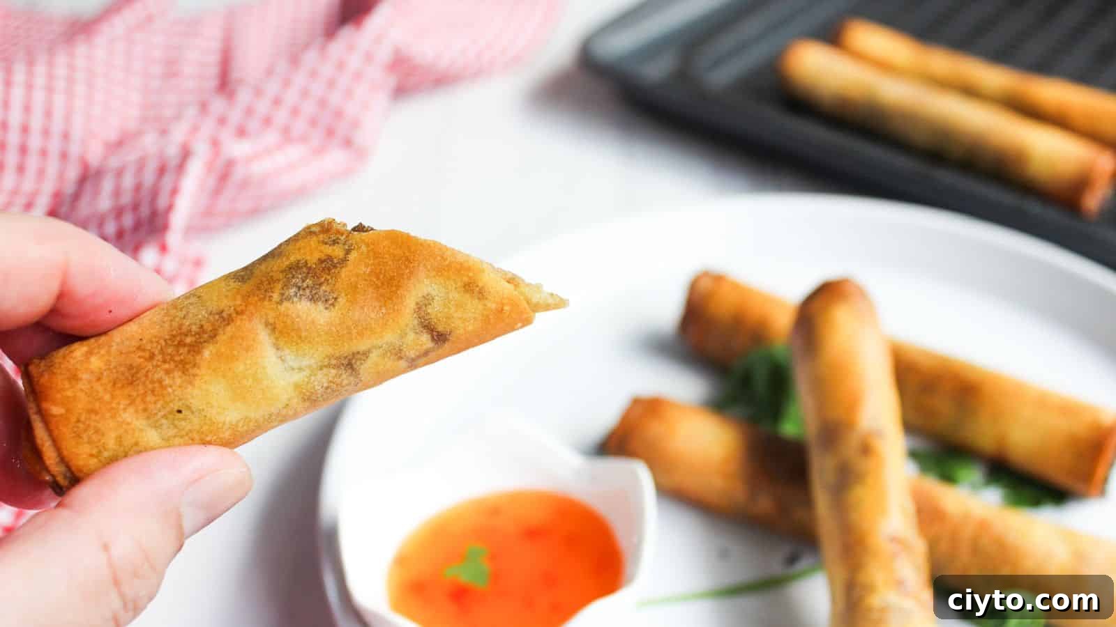 Filipino spring rolls in a basket with dipping sauce.
