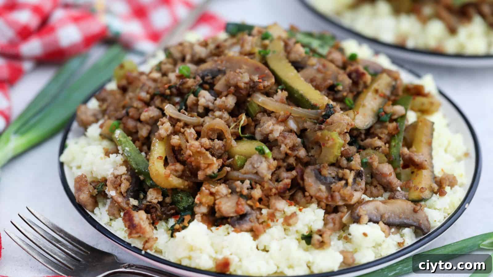 A plate with ground pork and vegetables on top of cauliflower rice.