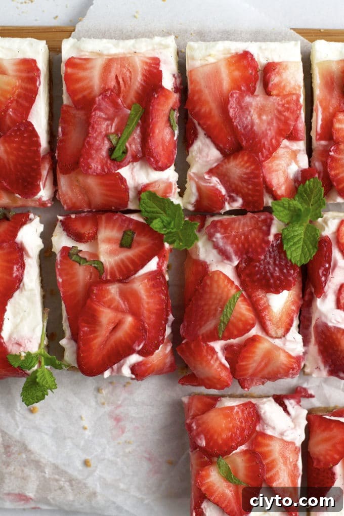 overhead look at no bake mascarpone cheesecake bars with fresh strawberries and mint