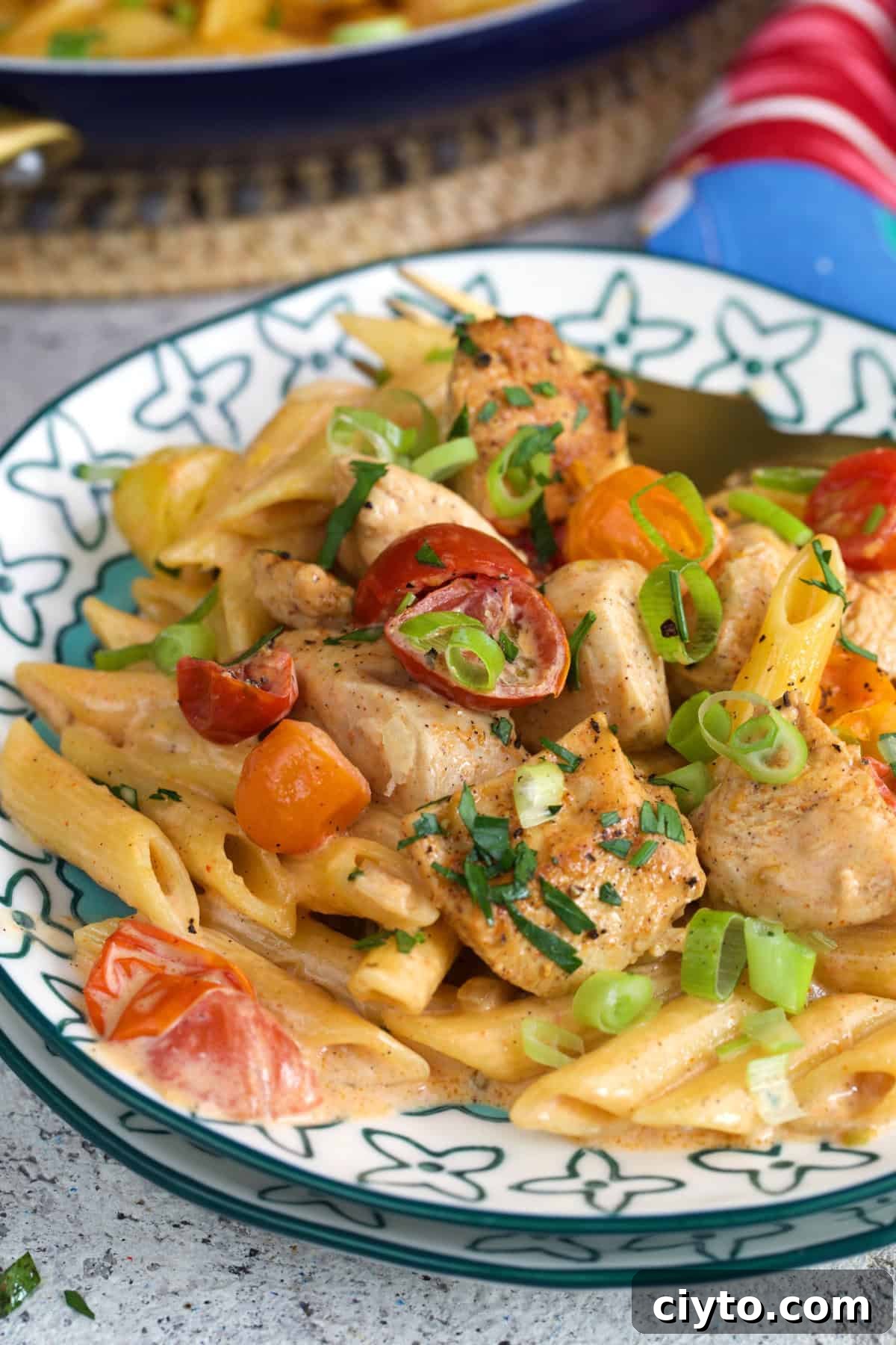 Cajun Chicken pasta on a plate topped with chopped green onions