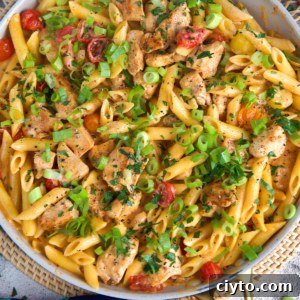 Cajun Chicken Pasta in a white skillet with a gold handle.