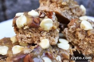 Caramel Pecan Oat Slice is a chewy oat slice studded with chocolate chips and topped with caramel, coconut, pecans and white chocolate. #caramelslice #carameloatbars #pecanoatbars #caramelpecanoatbars #pecancaramel #oatslice #oatmealbars