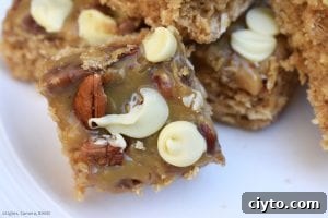 Caramel Pecan Oat Slice is a chewy oat slice studded with chocolate chips and topped with caramel, coconut, pecans and white chocolate. #caramelslice #carameloatbars #pecanoatbars #caramelpecanoatbars #pecancaramel #oatslice #oatmealbars