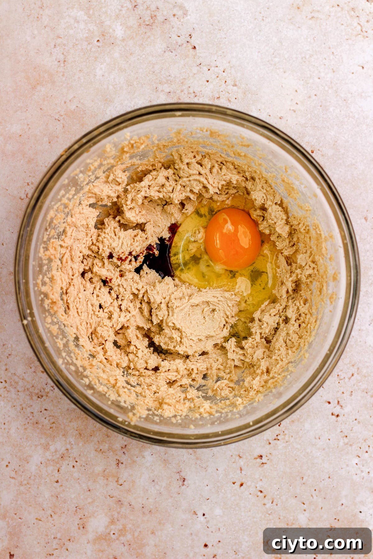A glass bowl filled with sugar cookie dough and eggs.