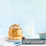 Maple syrup dripping down a stack of pancakes