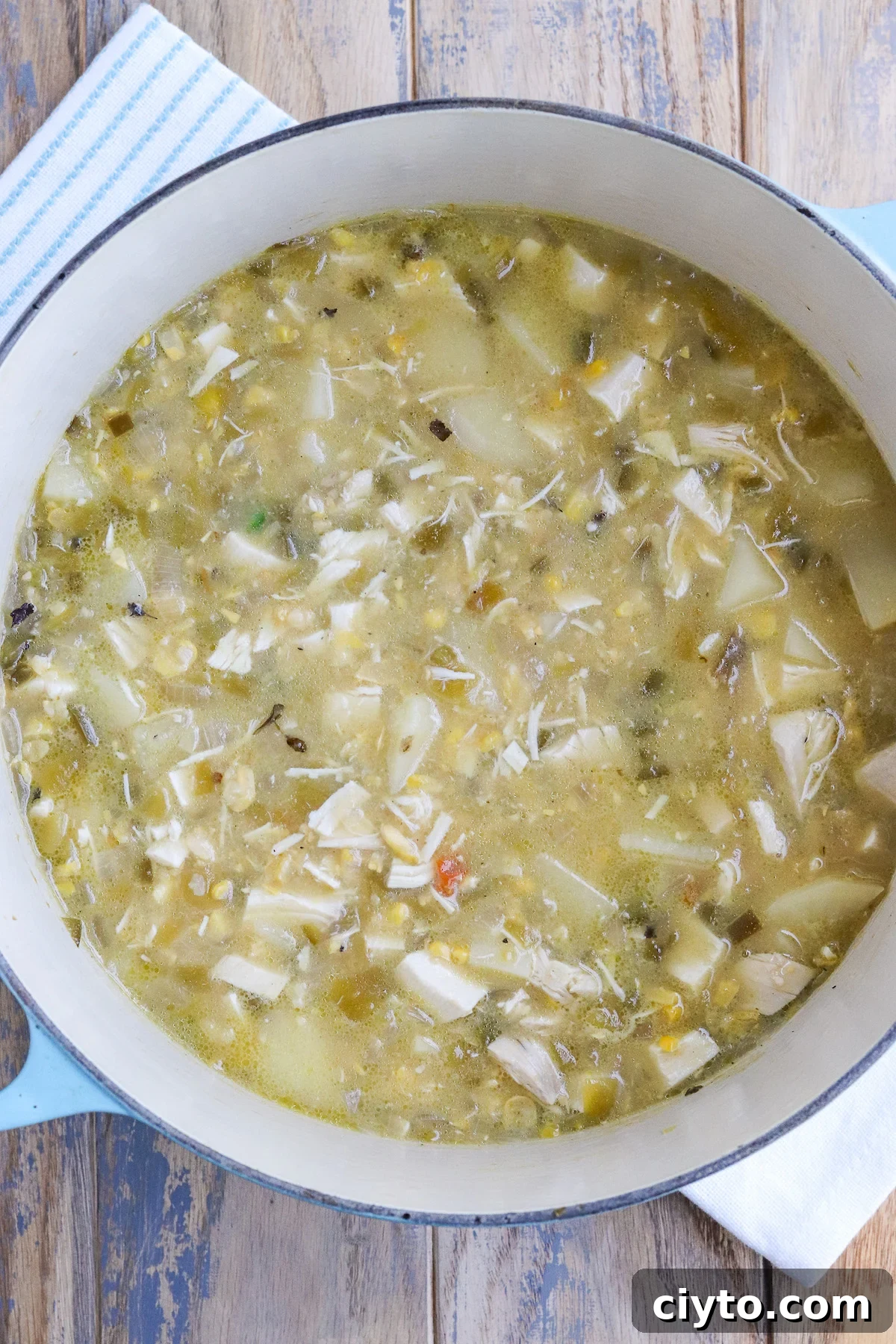 Green Chile Chicken Soup Recipe 5 dutch oven of cooked soup with visible potatoes and roasted hatch Green Chiles