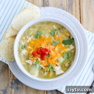 Green Chile Chicken Soup Recipe 8 closeup of bowl of hatch green Chile chicken soup topped with cheese and tomato