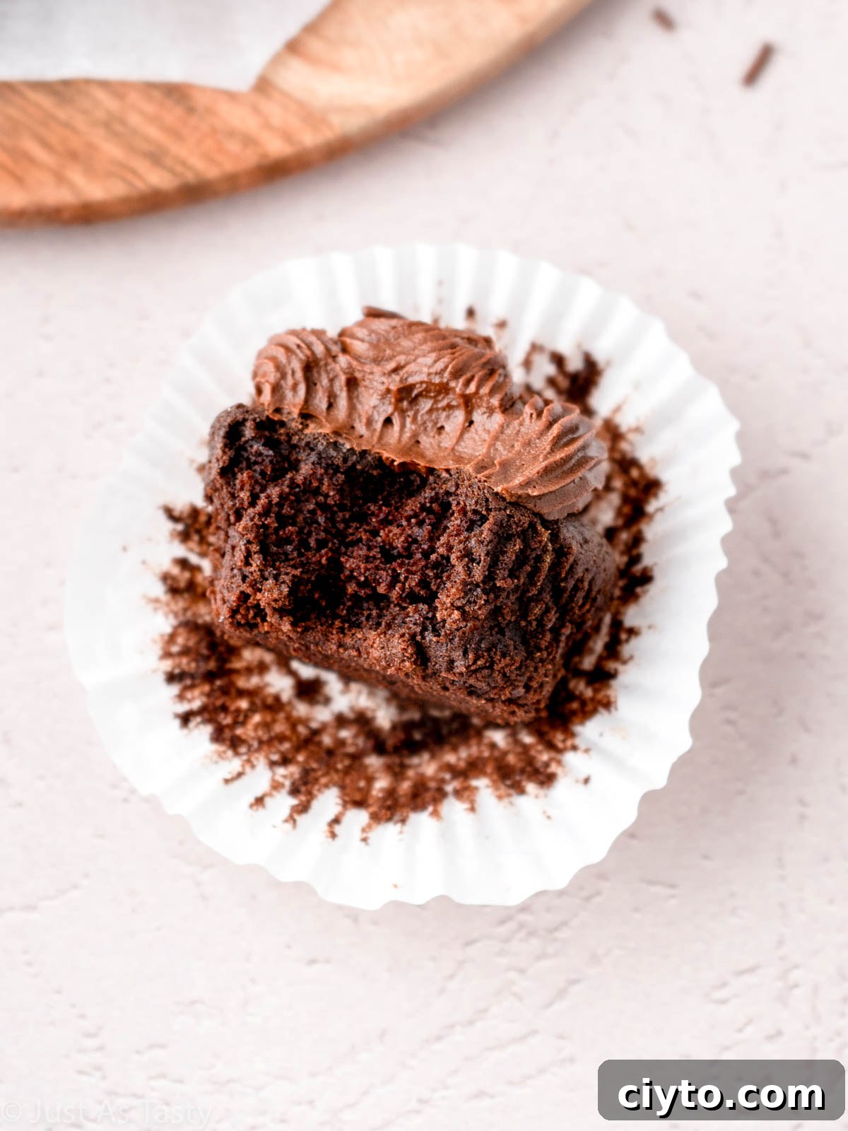 Frosted chocolate cupcake with bite taken out of it.