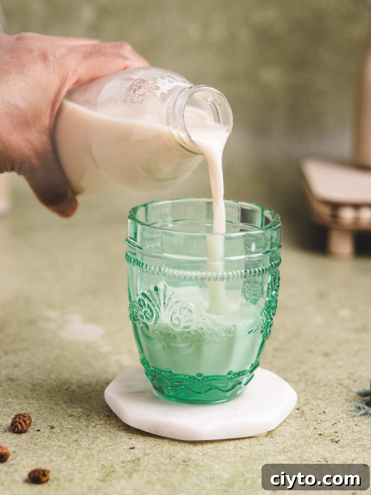 Pouring tiger nut milk into a glass cup.