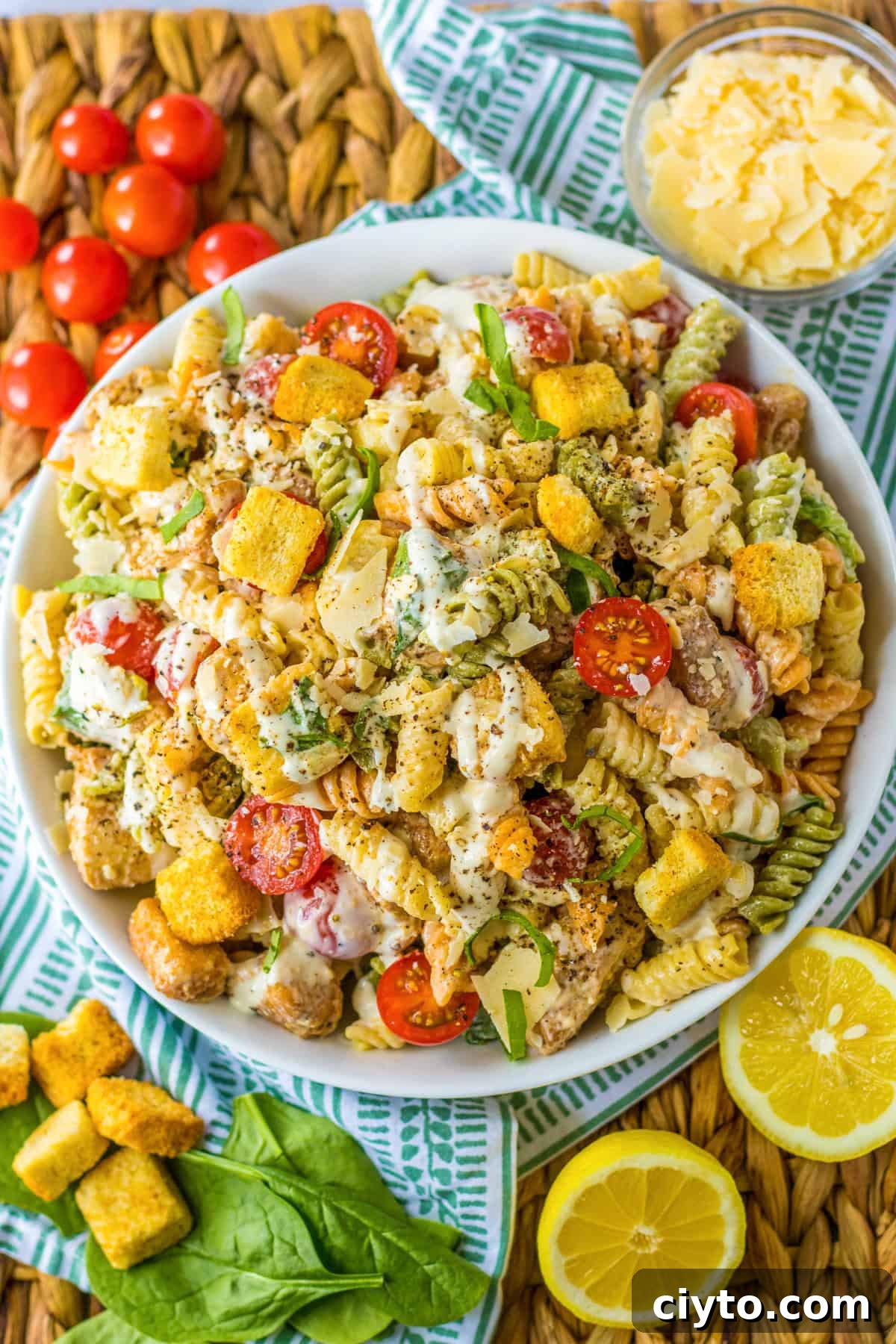 Chicken Caesar Pasta Salad Recipe with Crispy Croutons 2 Chicken Caesar Pasta Salad with lettuce, tomatoes, Parmesan cheese, and croutons.