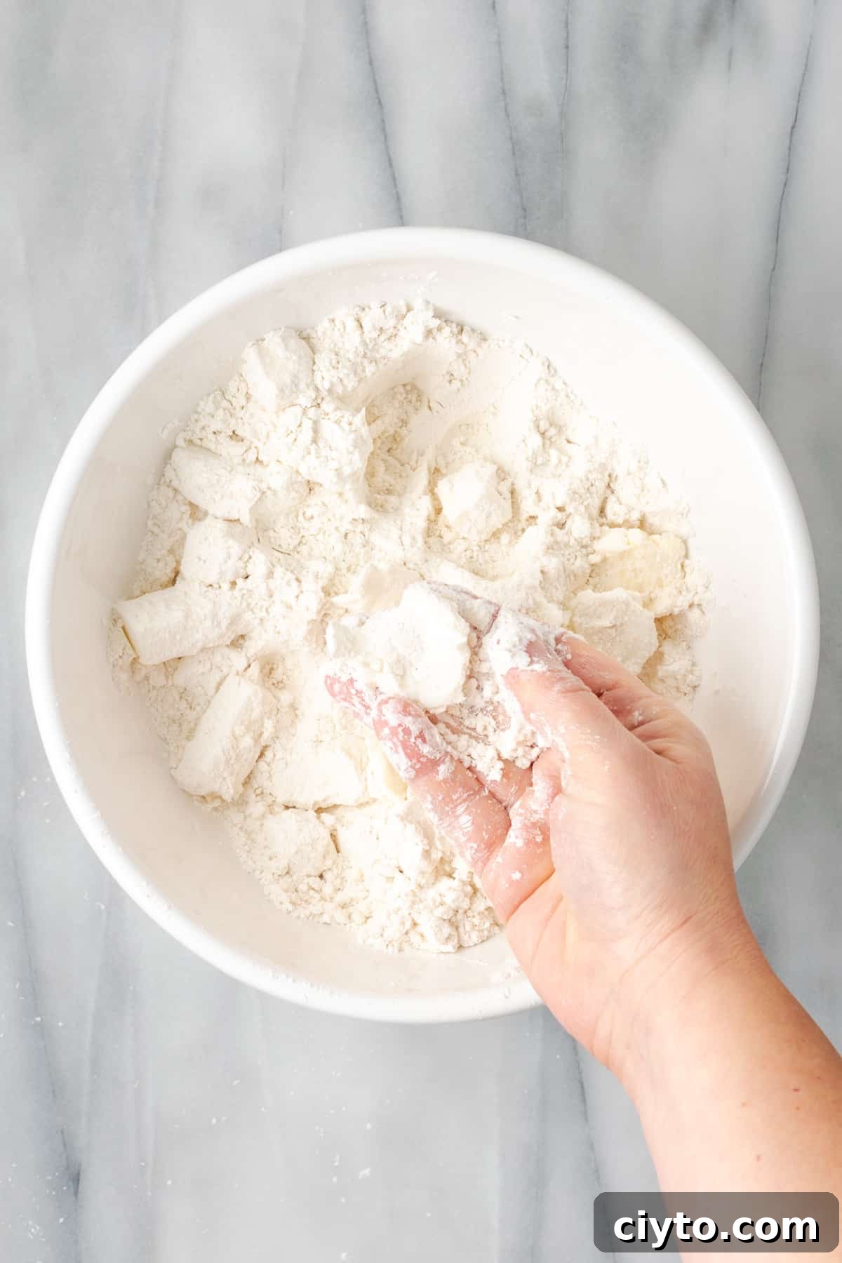 How to Make a Flaky Gluten-Free Pie Crust 10 A hand squishing cubes of butter into flattened discs.