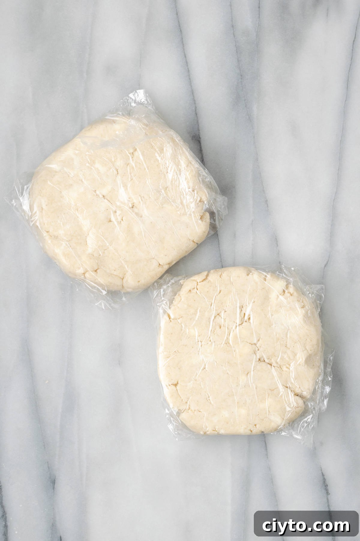 How to Make a Flaky Gluten-Free Pie Crust 13 Two portions of gluten free pie crust wrapped in plastic wrap.