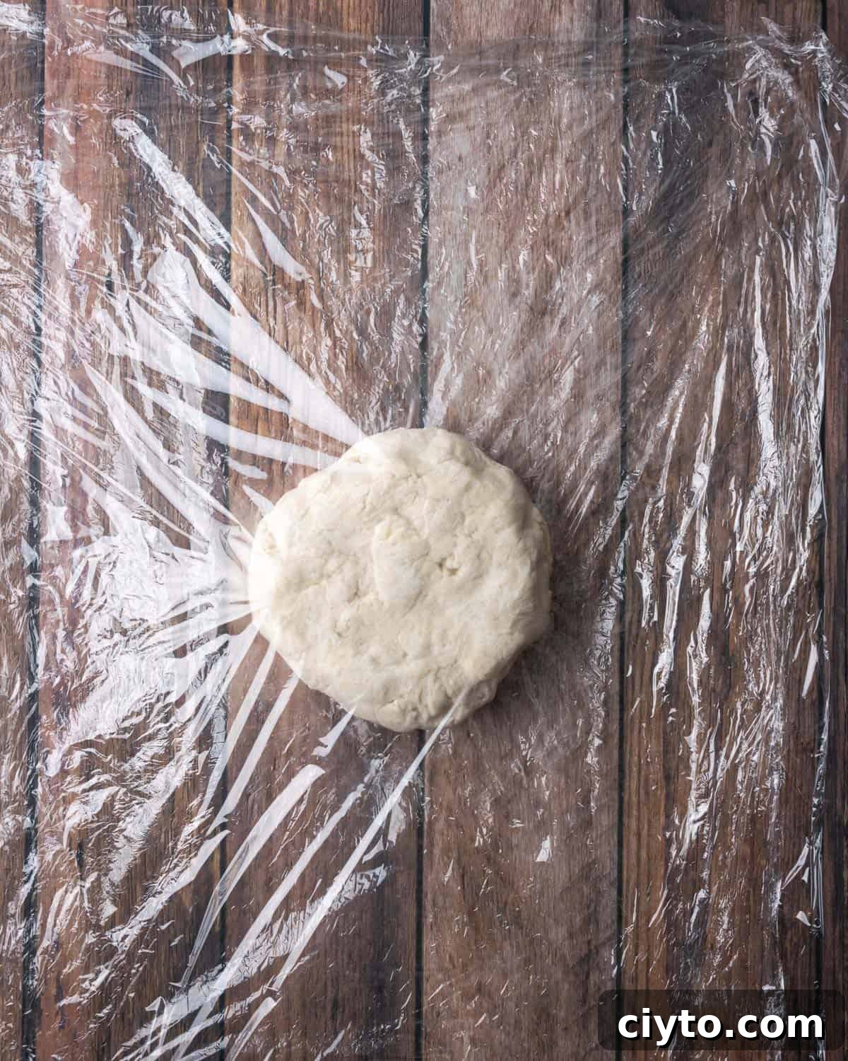 How to Make a Flaky Gluten-Free Pie Crust 15 A circle of pie dough in between two sheets of plastic wrap.