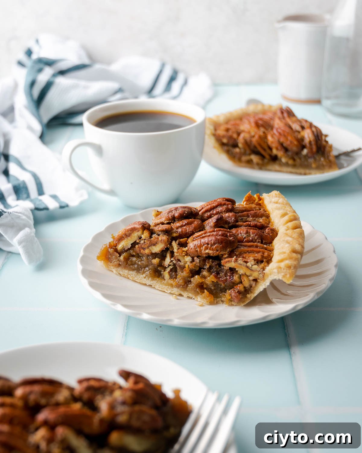 How to Make a Flaky Gluten-Free Pie Crust 3 A slice of gluten free pecan pie on a small plate served with a cup of coffee.