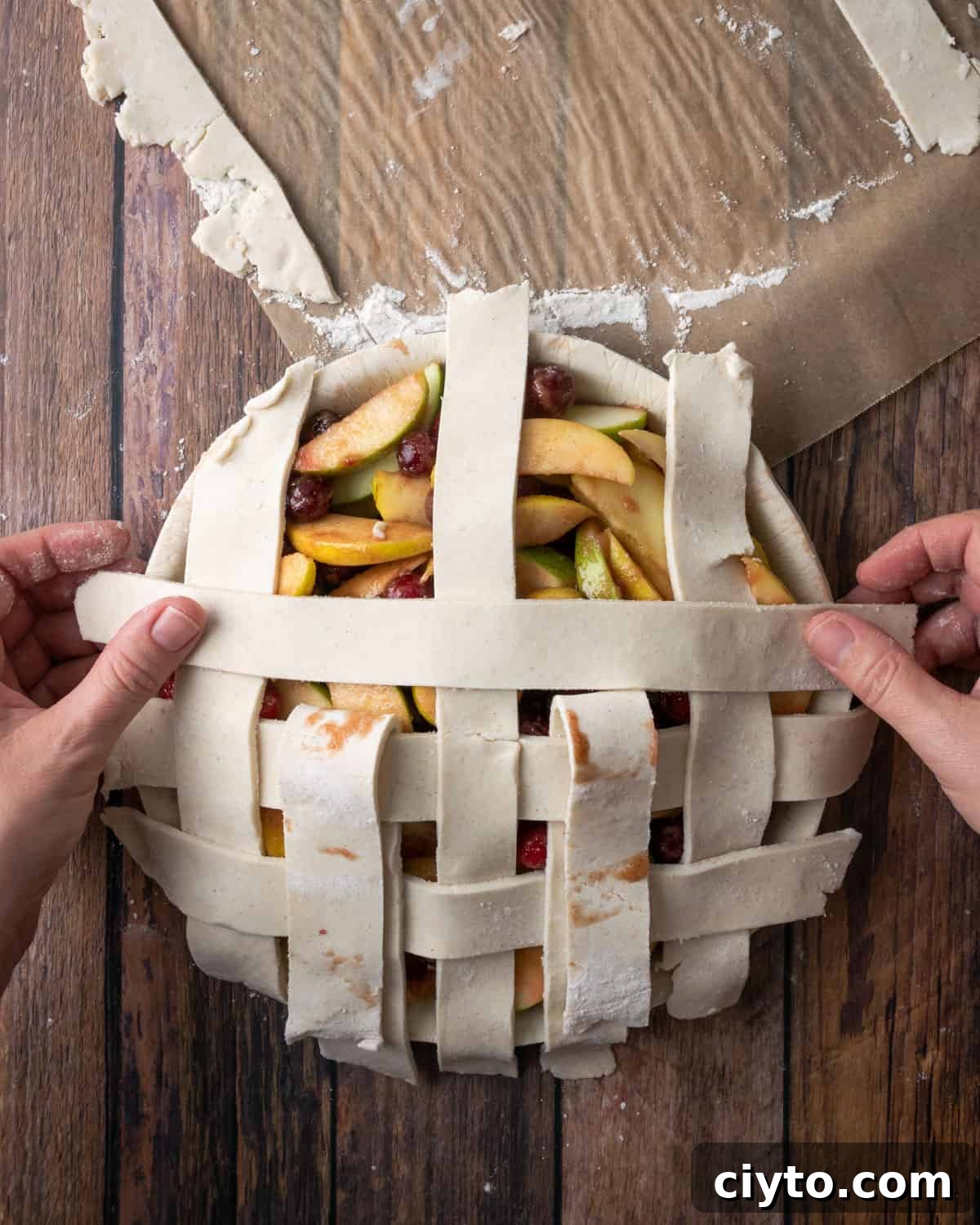 How to Make a Flaky Gluten-Free Pie Crust 23 A lattice grid being placed on top of an unbaked pie.