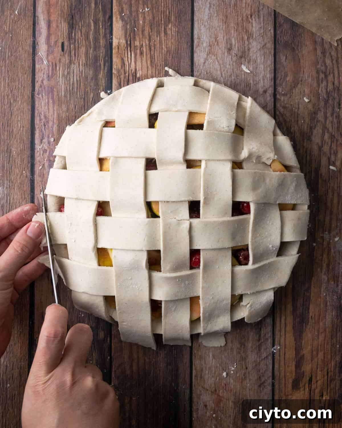 How to Make a Flaky Gluten-Free Pie Crust 24 A lattice topped pie being trimmed at the edges.