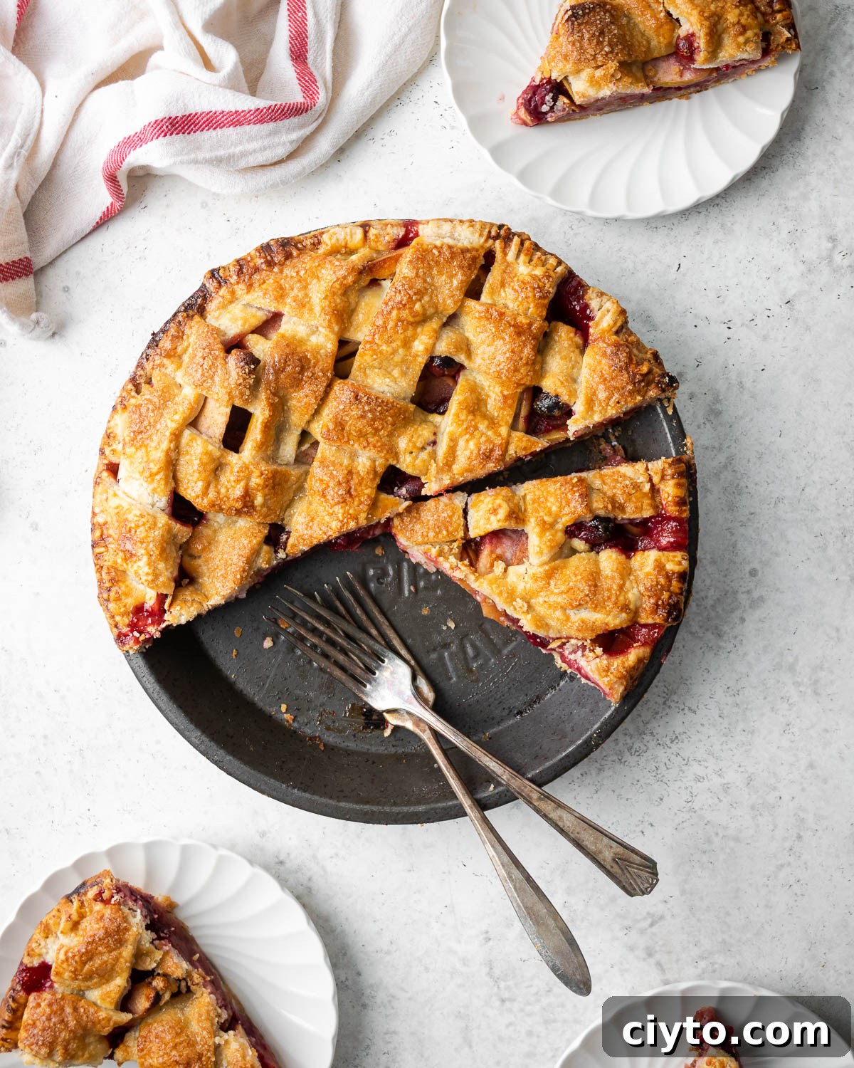 How to Make a Flaky Gluten-Free Pie Crust 7 A sliced gluten free apple cranberry pie on a white table.