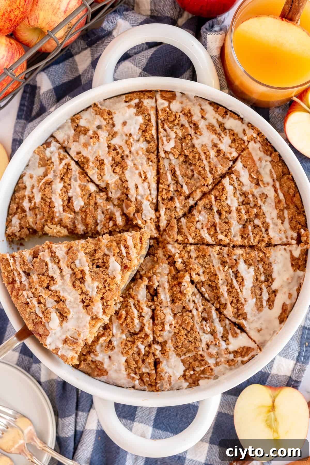 An over the top shot of a glazed Apple Cider Coffee Cake in a white baking dish.