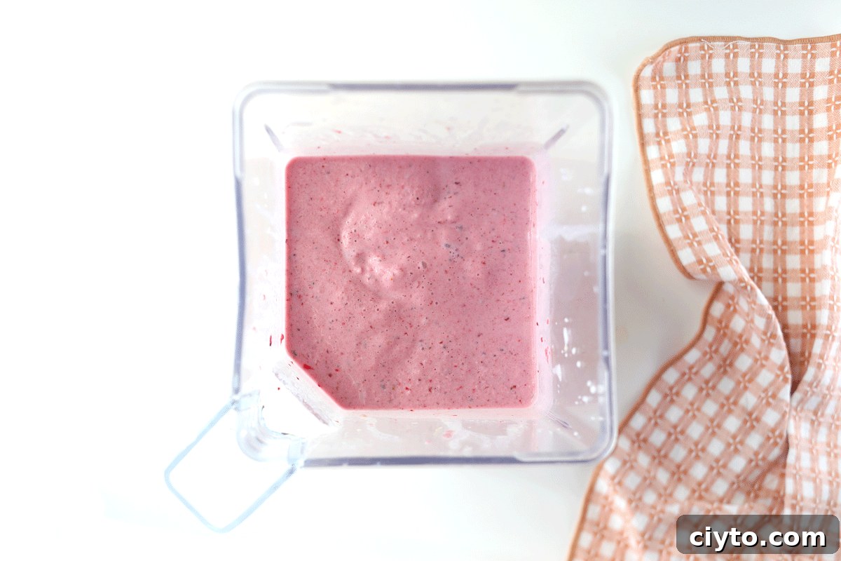 A blender with a yogurt fruit smoothie in it.