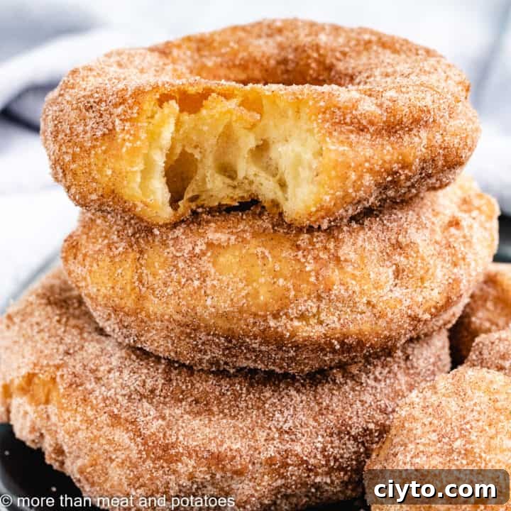 Three stacked donuts with donut holes.