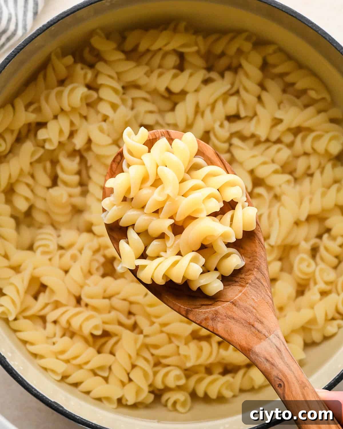 BLT Pasta Salad Recipe with Bacon, Tomato and Lettuce 6 a spoon scooping rotini noodles cooked in a pot out of the pot