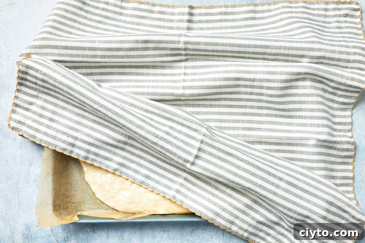 Baking pan covered with a striped cloth for the first rise.