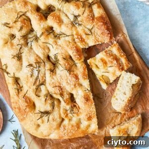 Sliced focaccia showing airy texture, crispy edges, and rosemary on top.