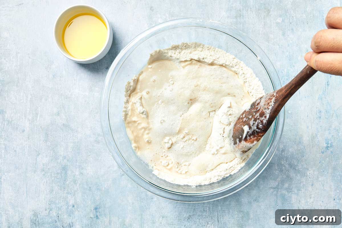 Mixing yeast and flour in a bowl with a wooden spoon.