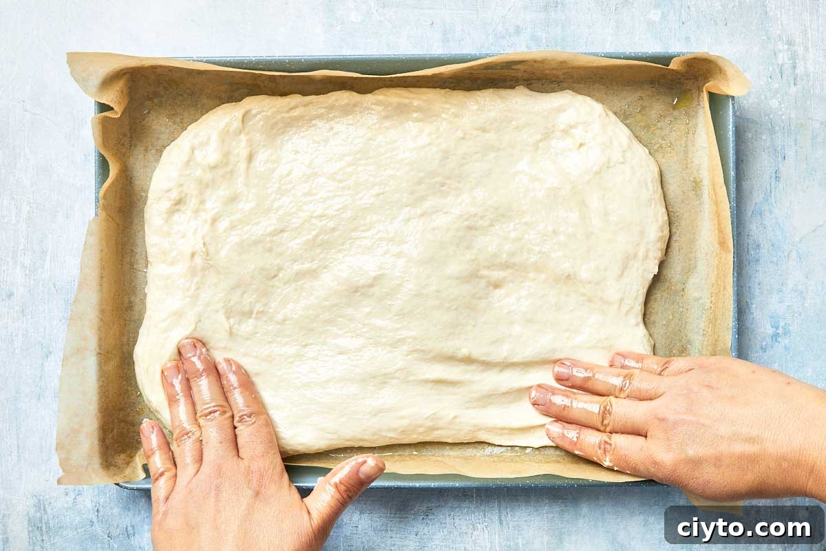Dough placed into the prepared pan and pressed out with fingers.