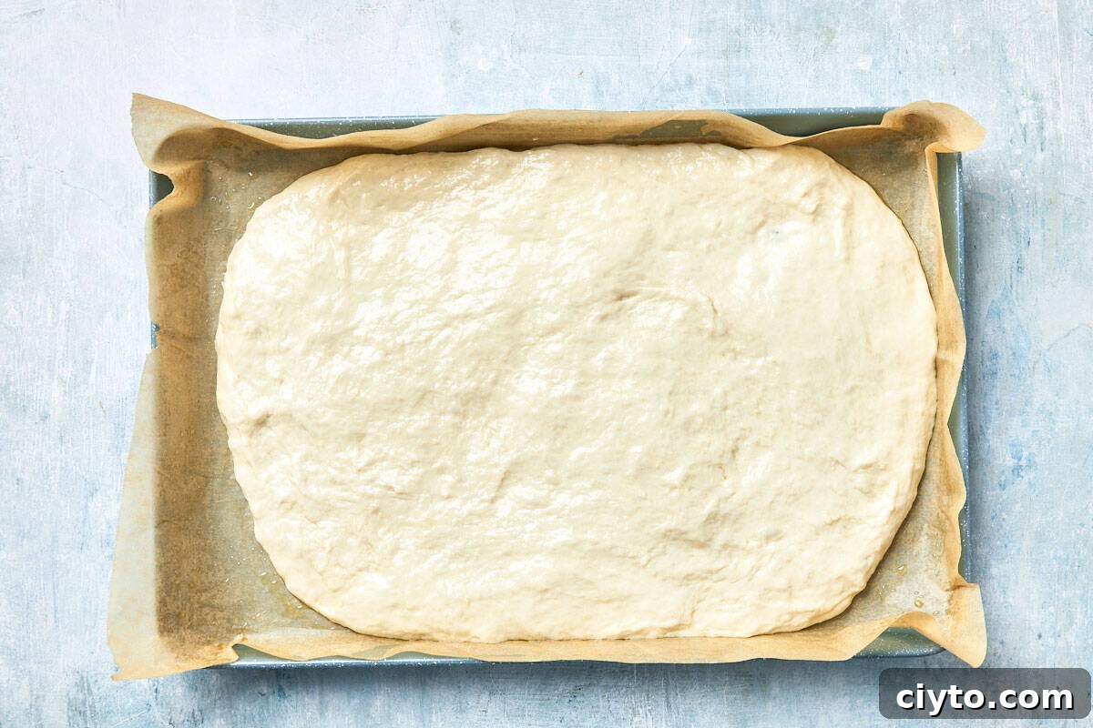 Dough spread fully in the baking pan, ready to rest.