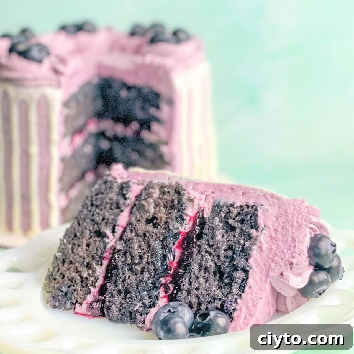 A slice of fresh blueberry cake with blueberry cake filling and blueberry buttercream.