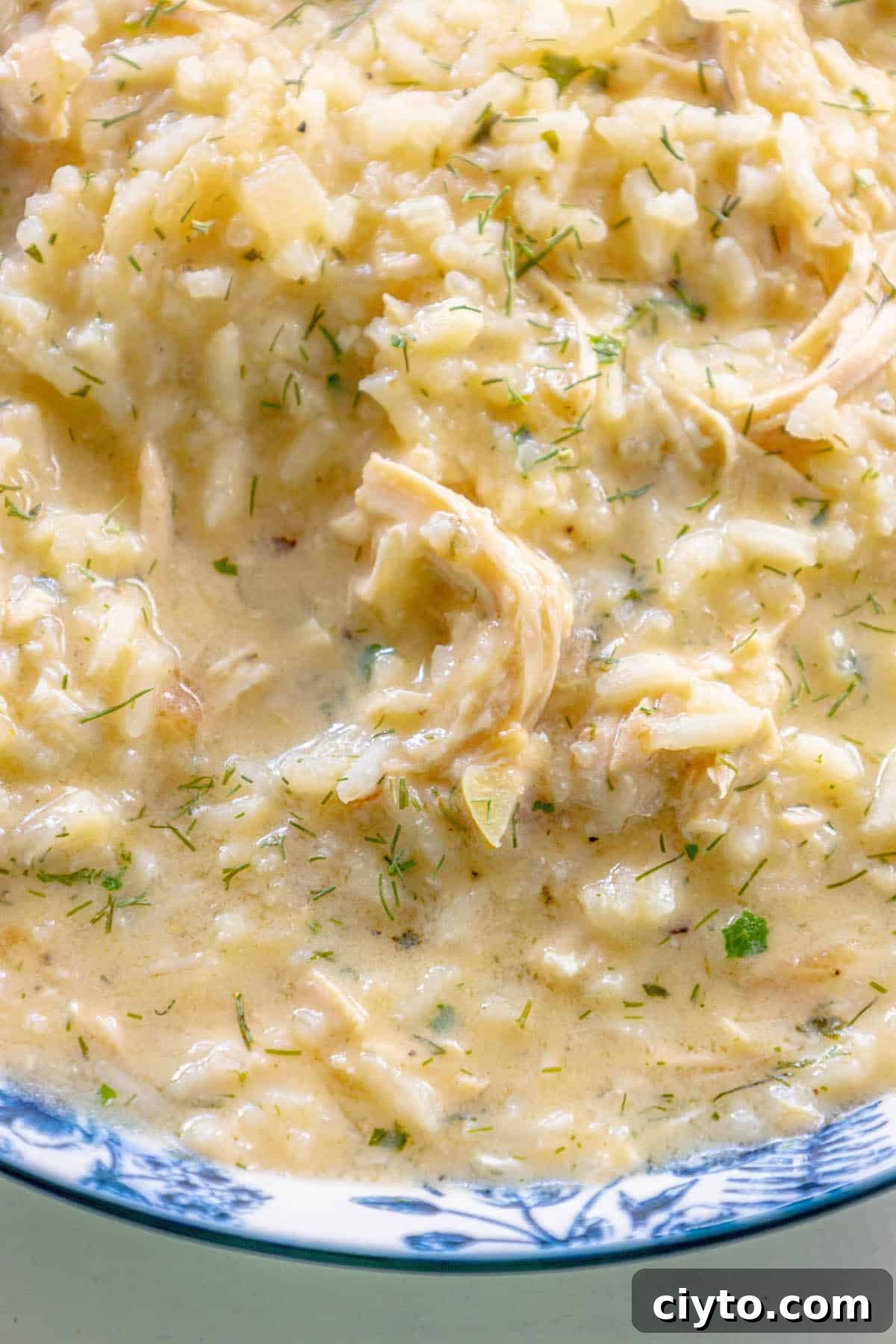 Authentic Greek Avgolemono Soup Recipe 6 Greek chicken risotto in a blue and white bowl.
