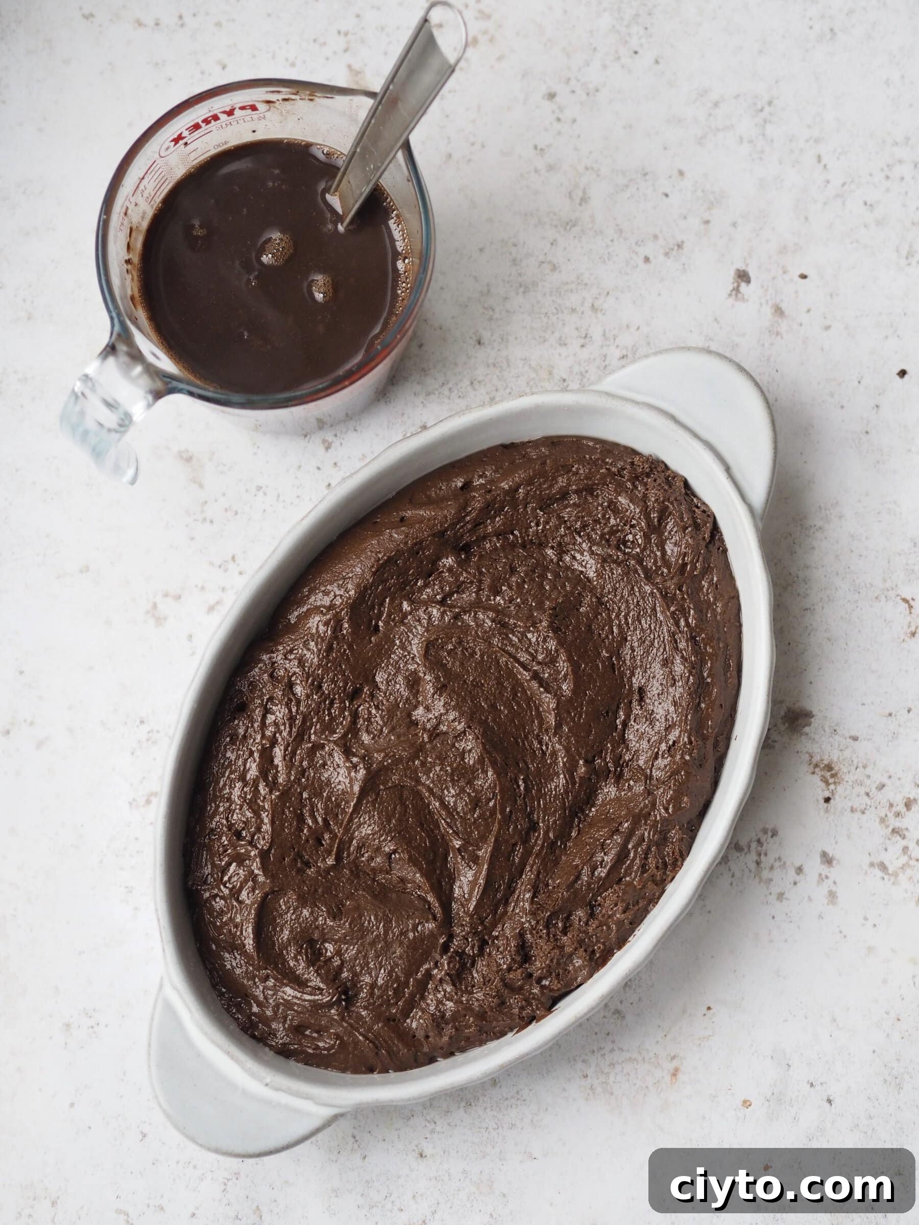 Chocolate Self-Saucing Pudding Recipe 8 batter poured into white baking dish.