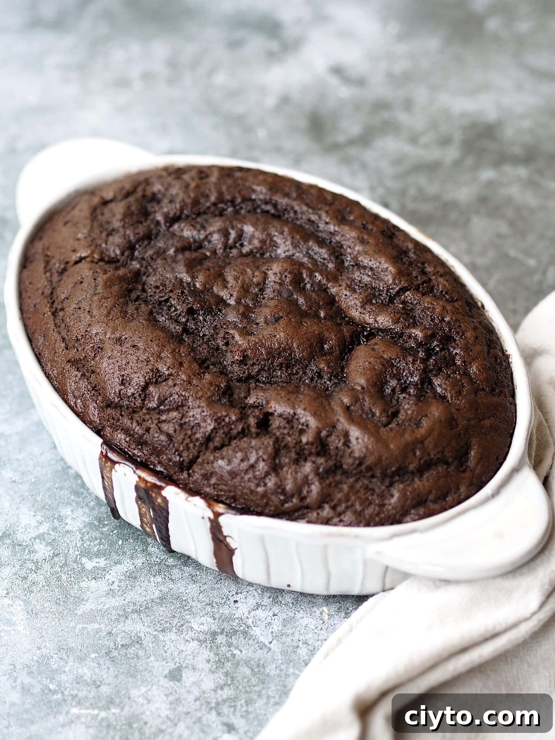 Chocolate Self-Saucing Pudding Recipe 10 baked Self Saucing Chocolate Pudding in a white baking dish.