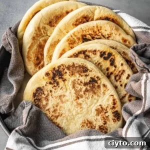 A bowl with a stack of freshly made Greek pitas.