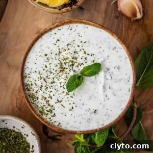 Mint yogurt sauce in a bowl with mint garnish.