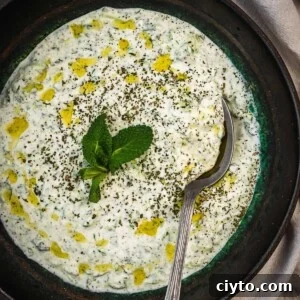 Turkish cacik in a bowl garnished with mint and olive oil.